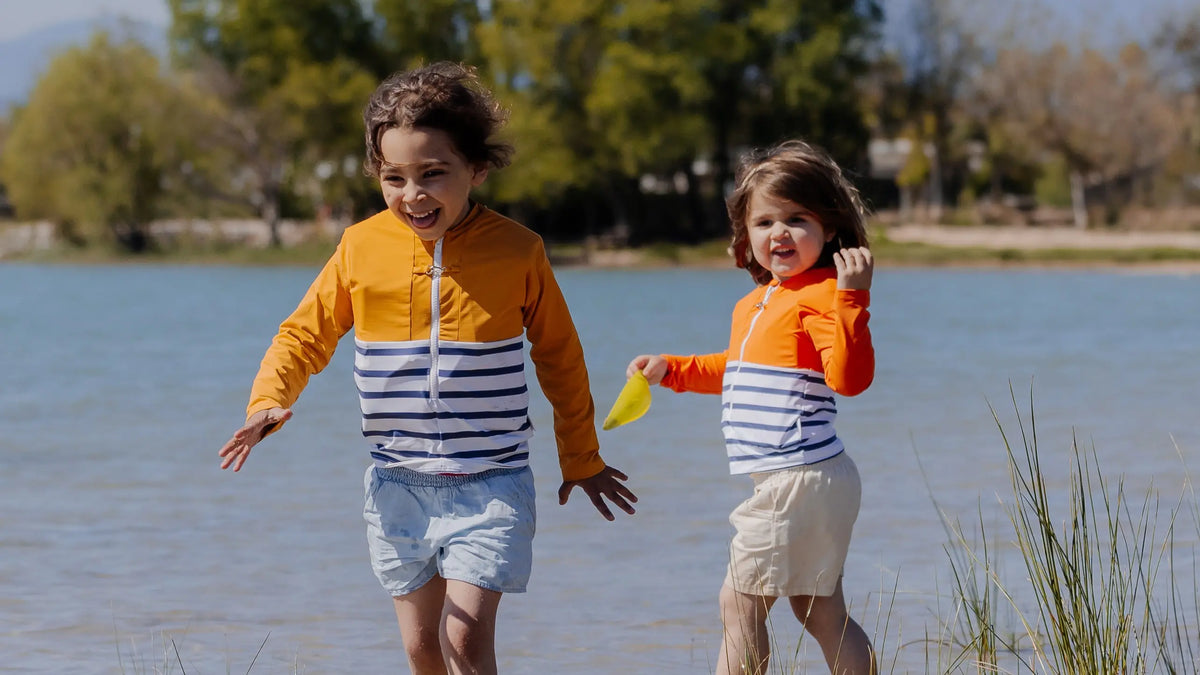 Deux jeunes filles au bord d'un lac portant des tee-shirts anti-noyade Floatee