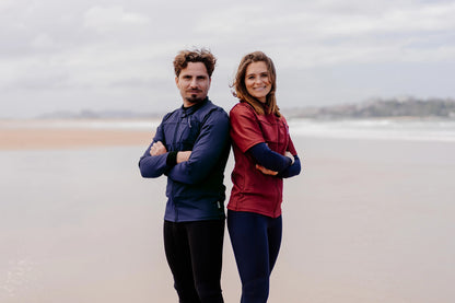 Homme et femme sur une plage et  portant le tee-shirt anti-noyade adulte automatique Floatee (homme : bleu, femme : rouge)