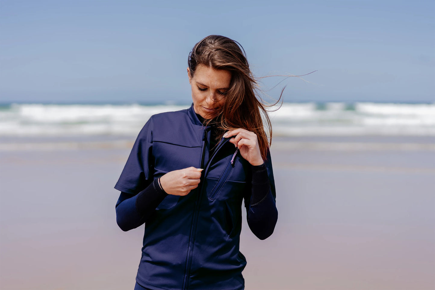 Femme sur une plage et portant le tee-shirt anti-noyade adulte automatique Floatee, manches courtes, bleu