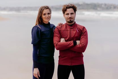 Homme et femme sur une plage et  portant le tee-shirt anti-noyade adulte automatique Floatee (homme : rouge, femme : bleu)