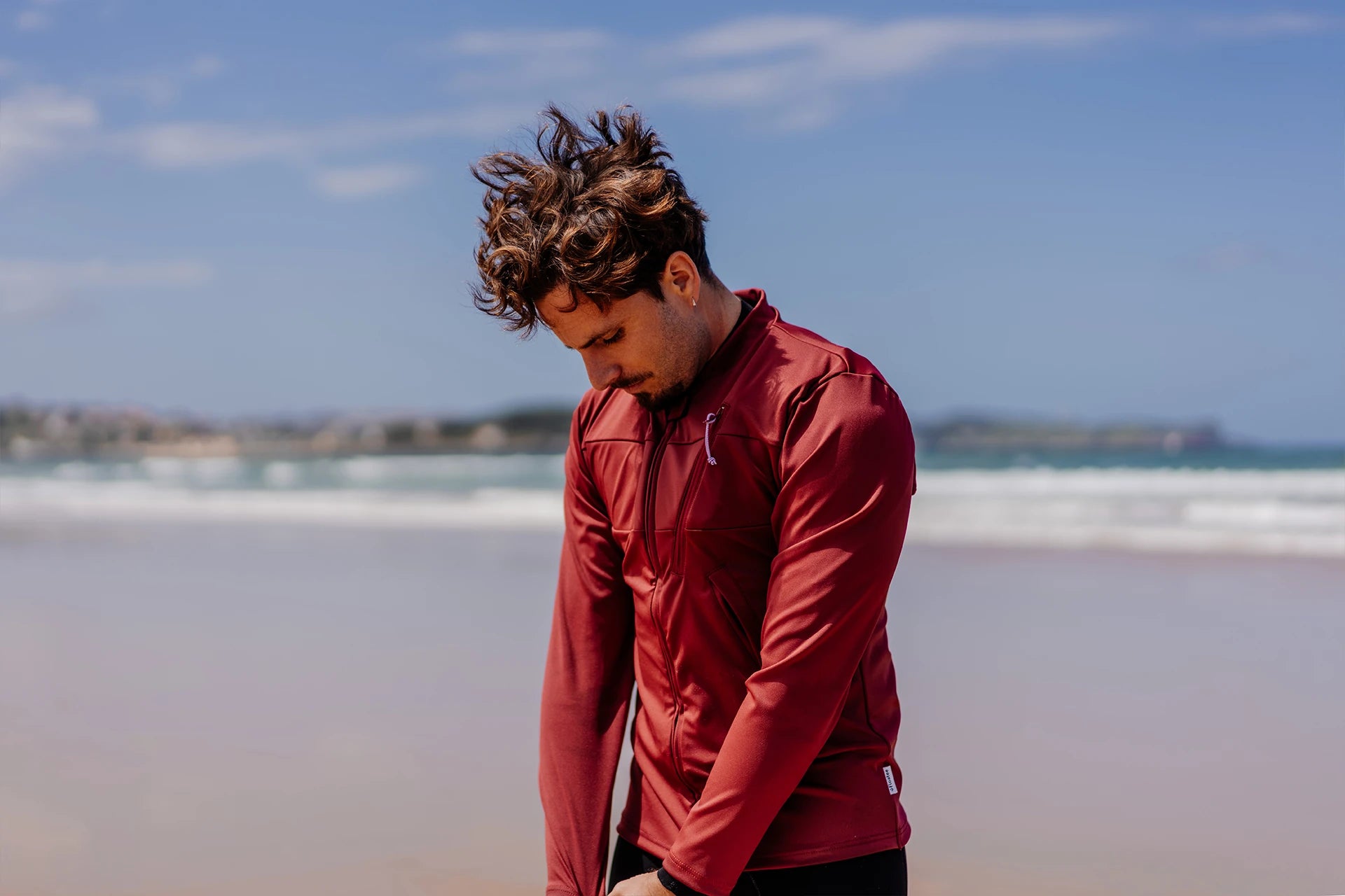 Homme sur une plage et portant le tee-shirt anti-noyade adulte manuel Floatee, manches longues, rouge