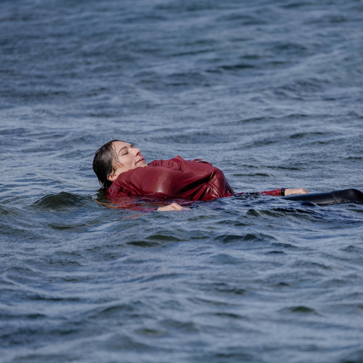 femme en mer portant un T-shirt anti-noyade Floatee rouge à manches longues, gonflé