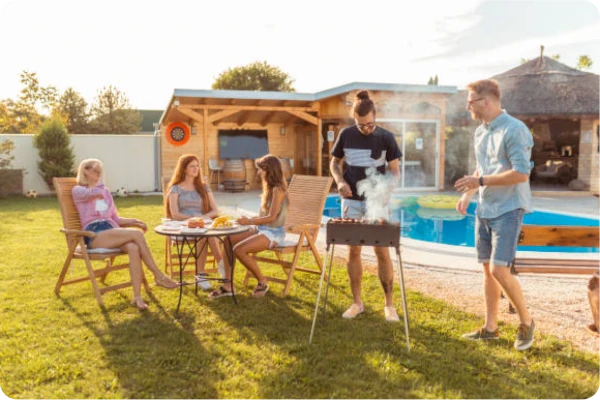 Famille partageant un barbecue dans le jardin avec piscine sans protection, sans penser à la solution anti-noyade Floatee