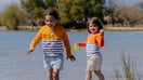Deux jeunes filles au bord d'un lac portant des tee-shirts anti-noyade Floatee