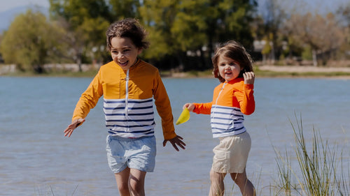 Deux jeunes filles au bord d'un lac portant des tee-shirts anti-noyade Floatee