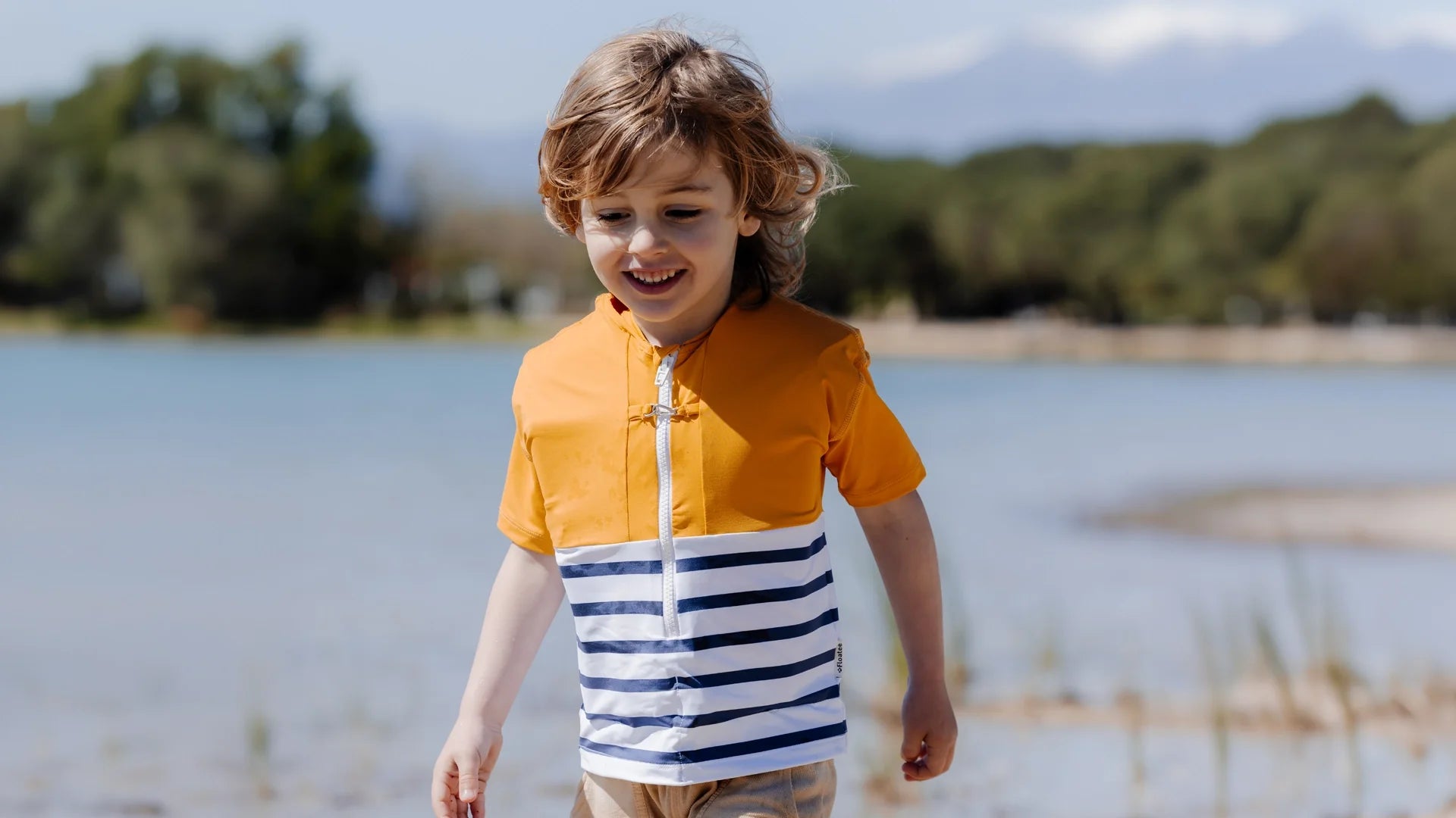 Enfant portant le tee-shirt anti-noyade Sheltom au bord de l'eau
